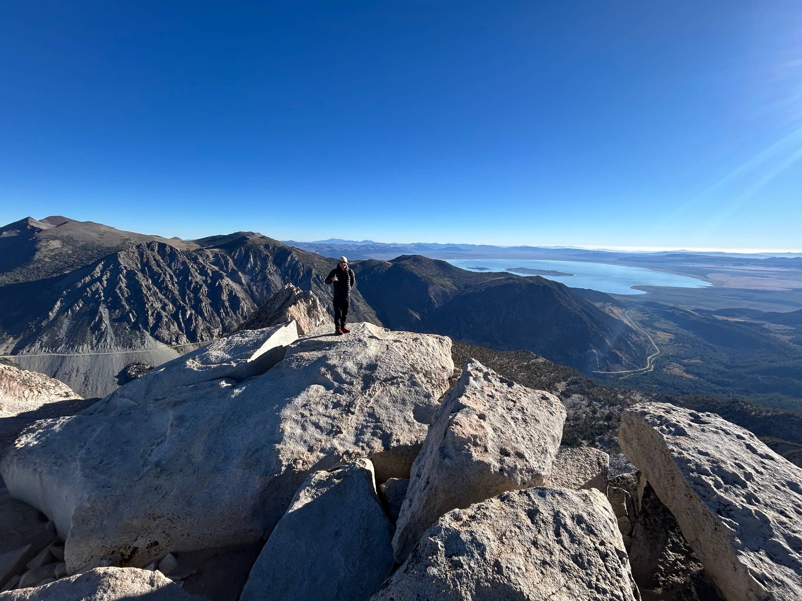 Jacob Majors standing on a mountain summit overlooking Mono Lake